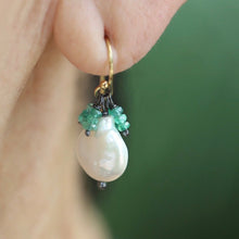 Load image into Gallery viewer, Close-up of an earring with a pearl and emerald gemstones worn by a person.
